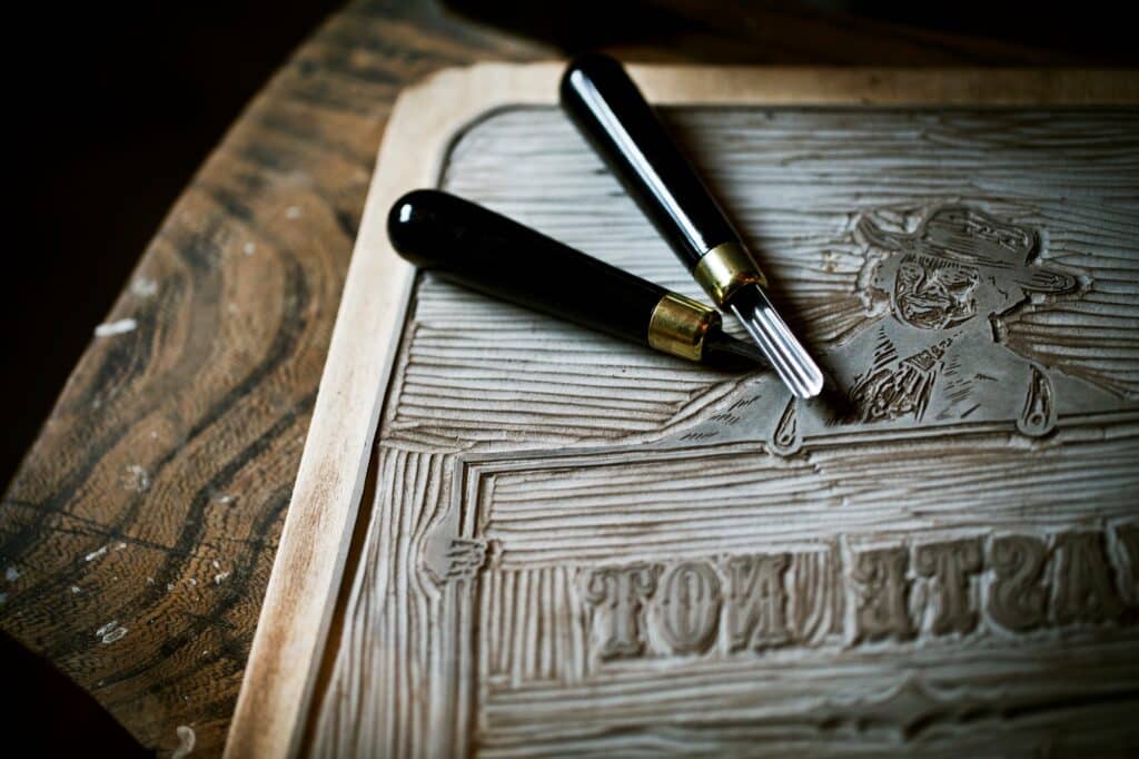 A sheet of linoleum and cutting tools, a design for a linocut print.