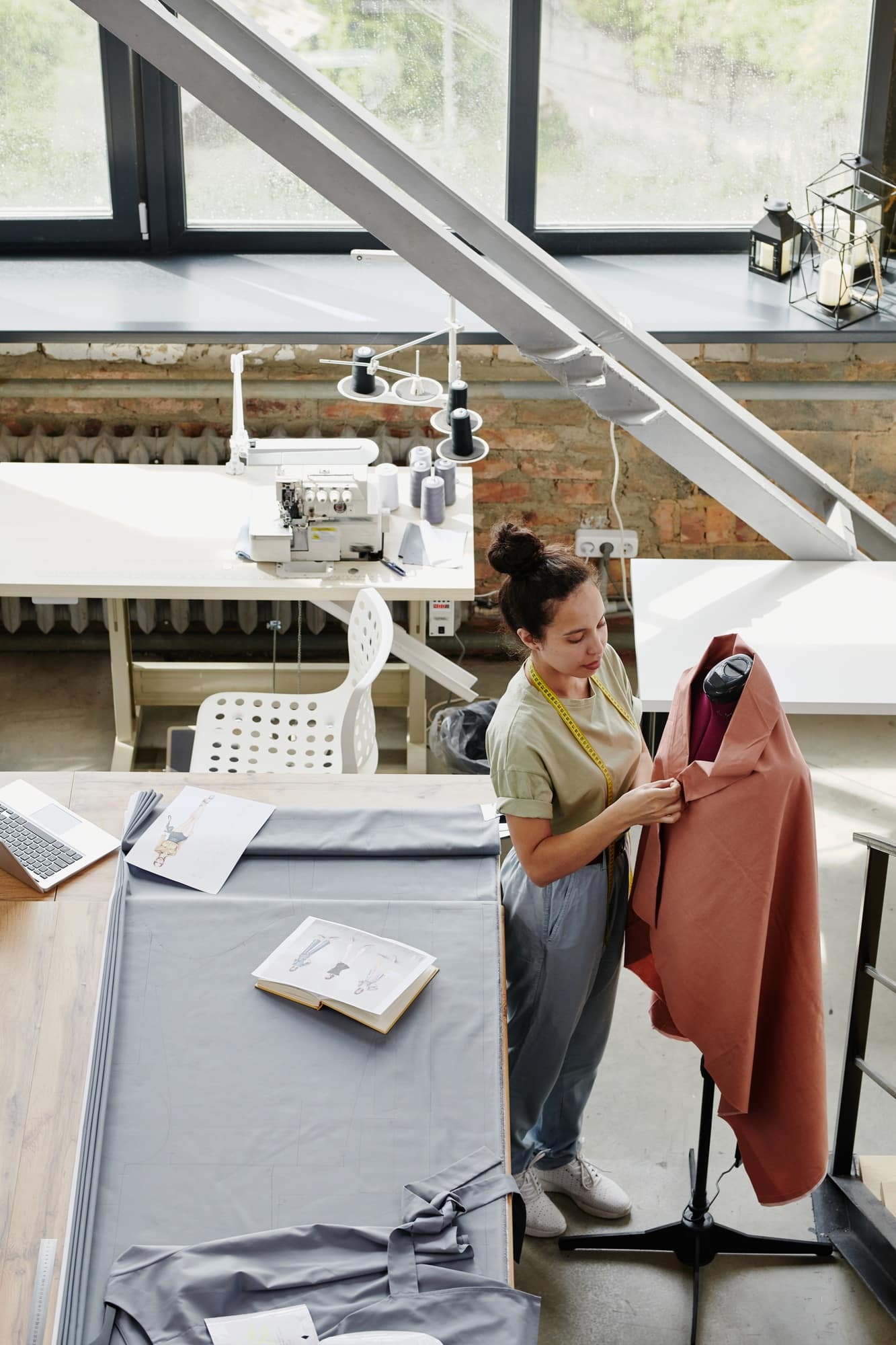 Young contemporary fashion designer working with textile on dummy