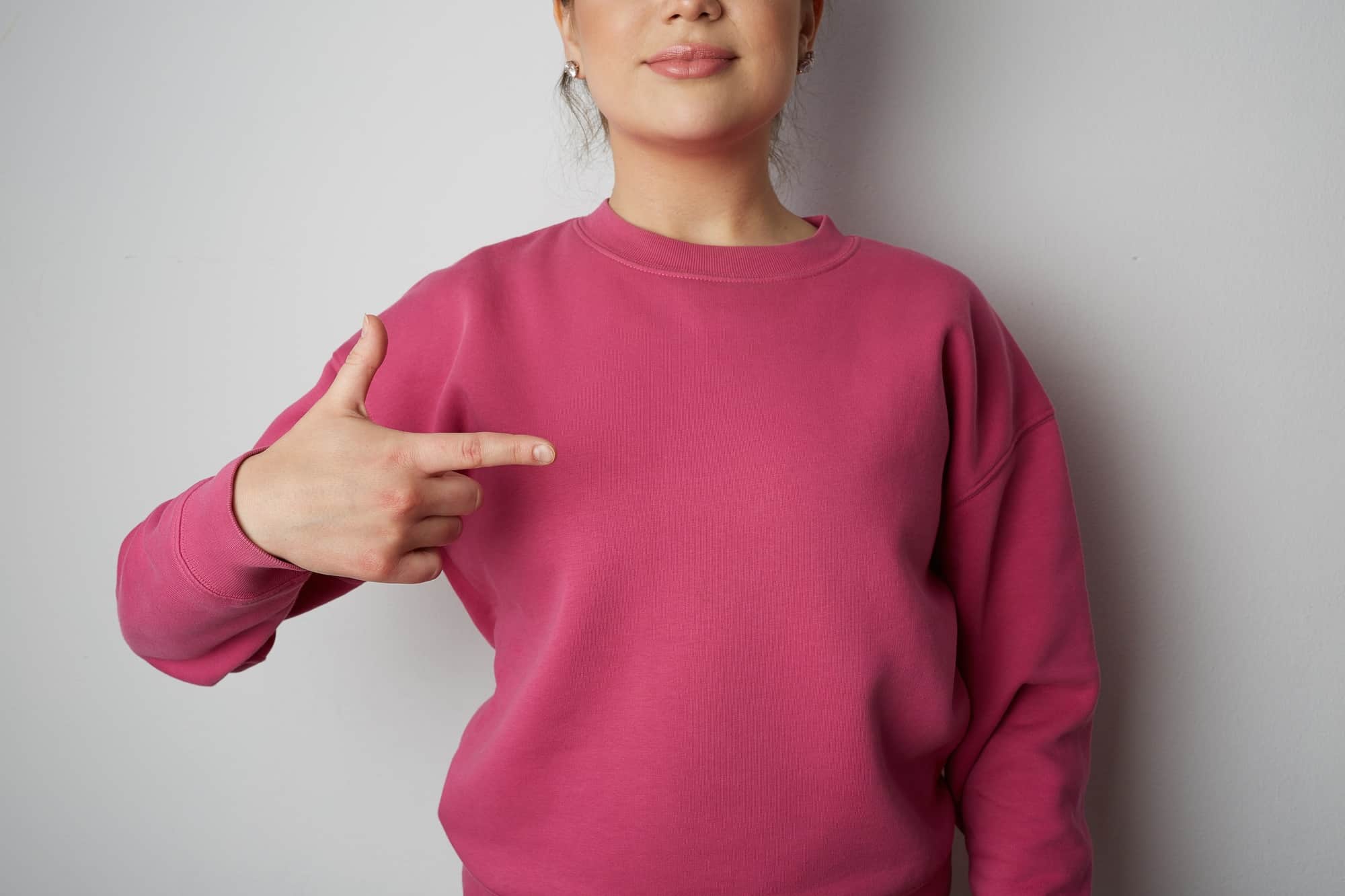 Young hipster girl wearing pink hoody with space for your logo or design. Mock-up of pink hoody