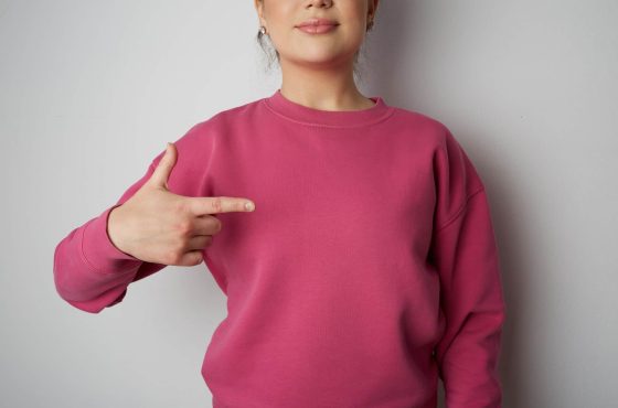 Young hipster girl wearing pink hoody with space for your logo or design. Mock-up of pink hoody